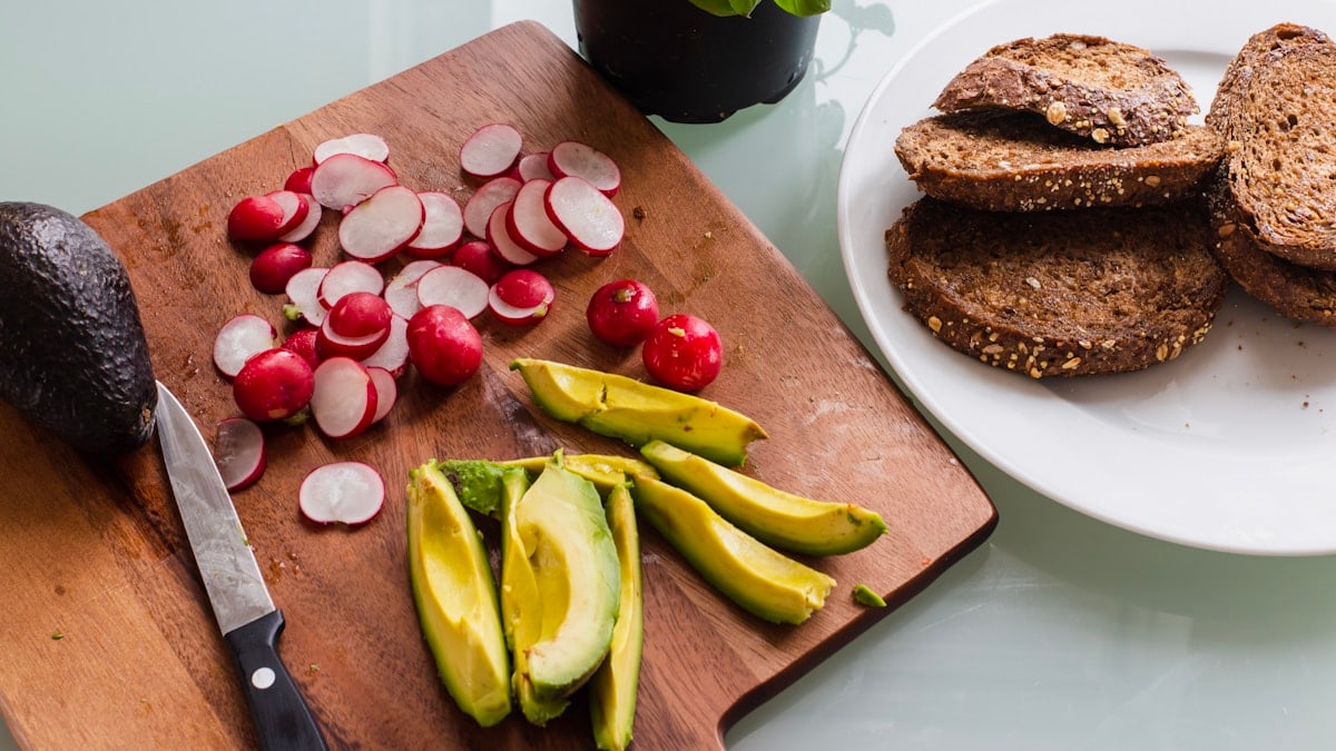 banana fruit and bread on brown wooden chopping board