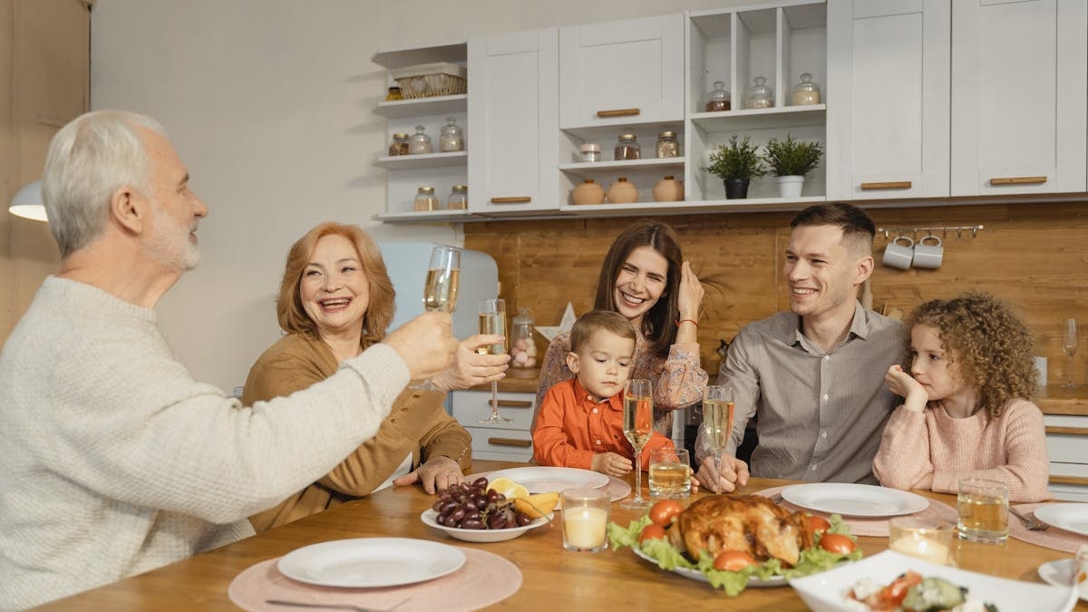 A joyful family gathering at home, celebrating Thanksgiving with food and smiles.
